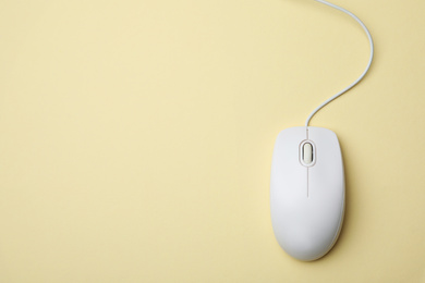 Photo of Wired computer mouse on yellow background, top view. Space for text