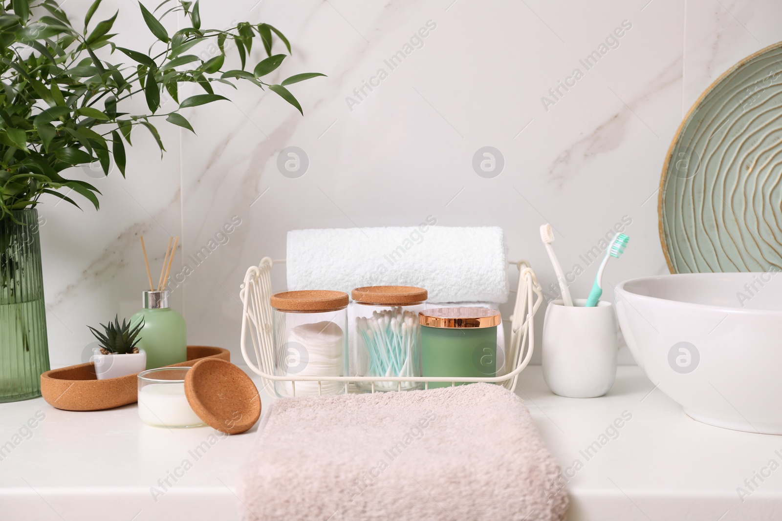 Photo of Personal hygiene products on table near white wall in bathroom