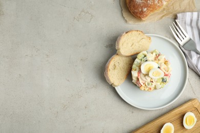 Delicious salad with crab sticks and eggs served on grey table, flat lay. Space for text