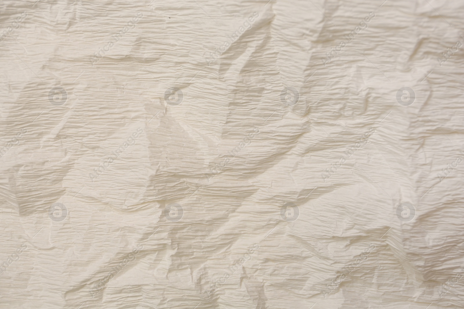 Photo of Texture of crumpled beige paper as background, closeup view