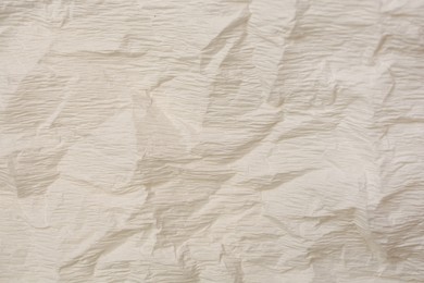 Texture of crumpled beige paper as background, closeup view