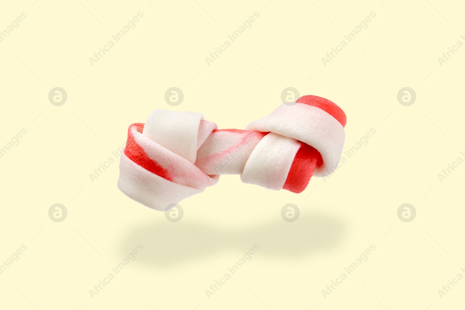 Image of Bone dog treat in air on beige background