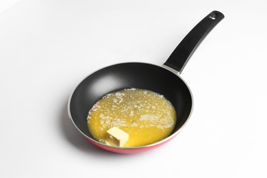 Photo of Frying pan with melting butter on white background