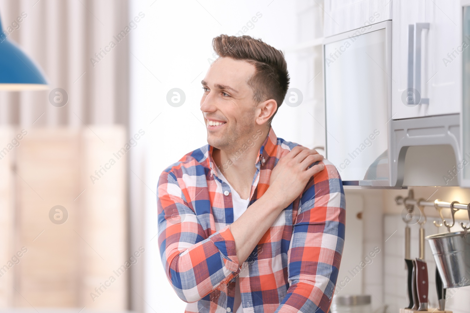 Photo of Portrait of handsome young man in kitchen