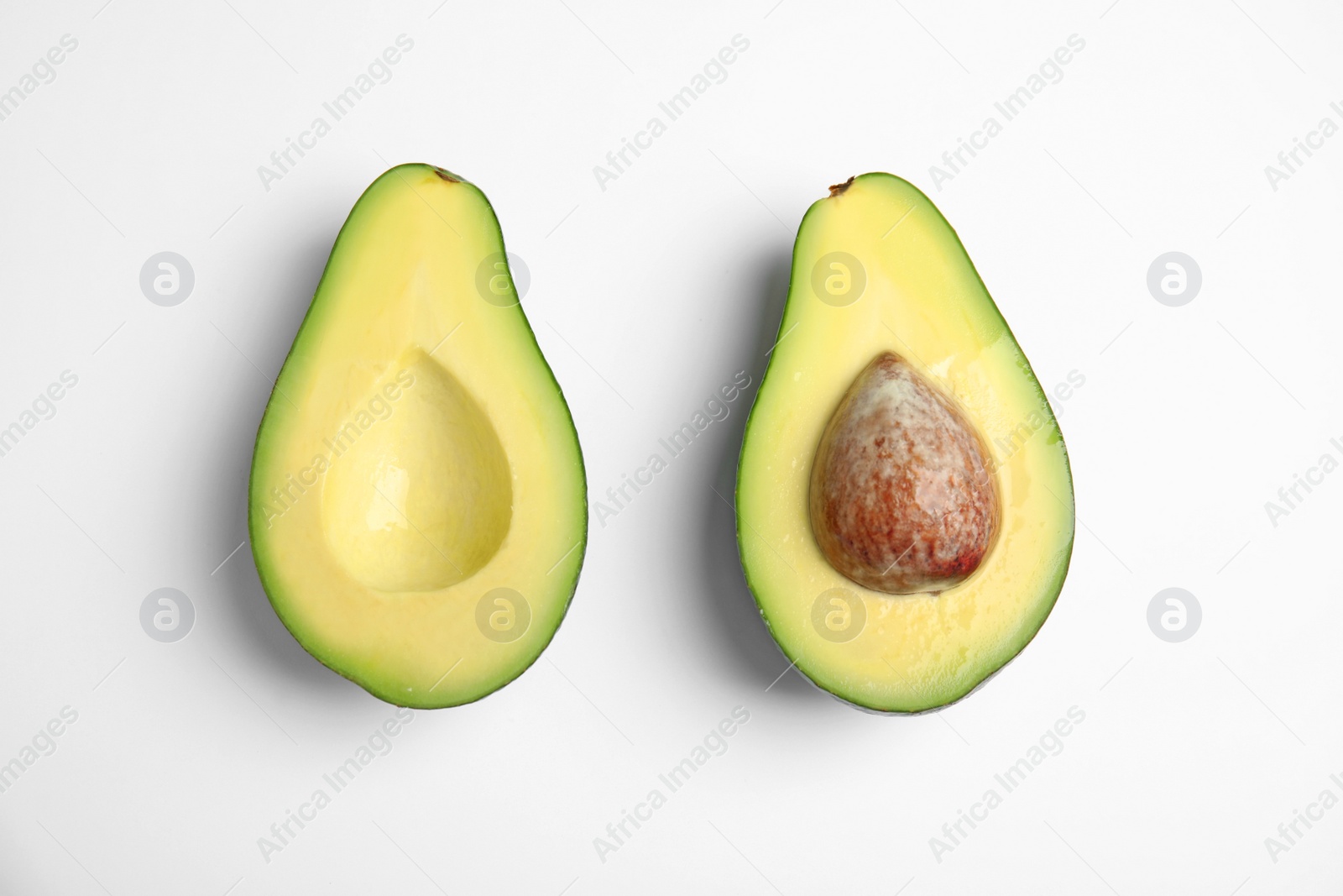 Photo of Cut fresh ripe avocado on white background, top view