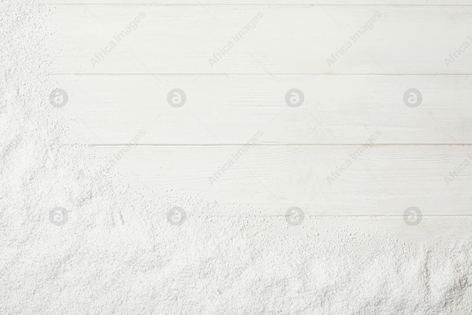 Photo of Artificial snow on white wooden background, top view with space for text. Christmas decor