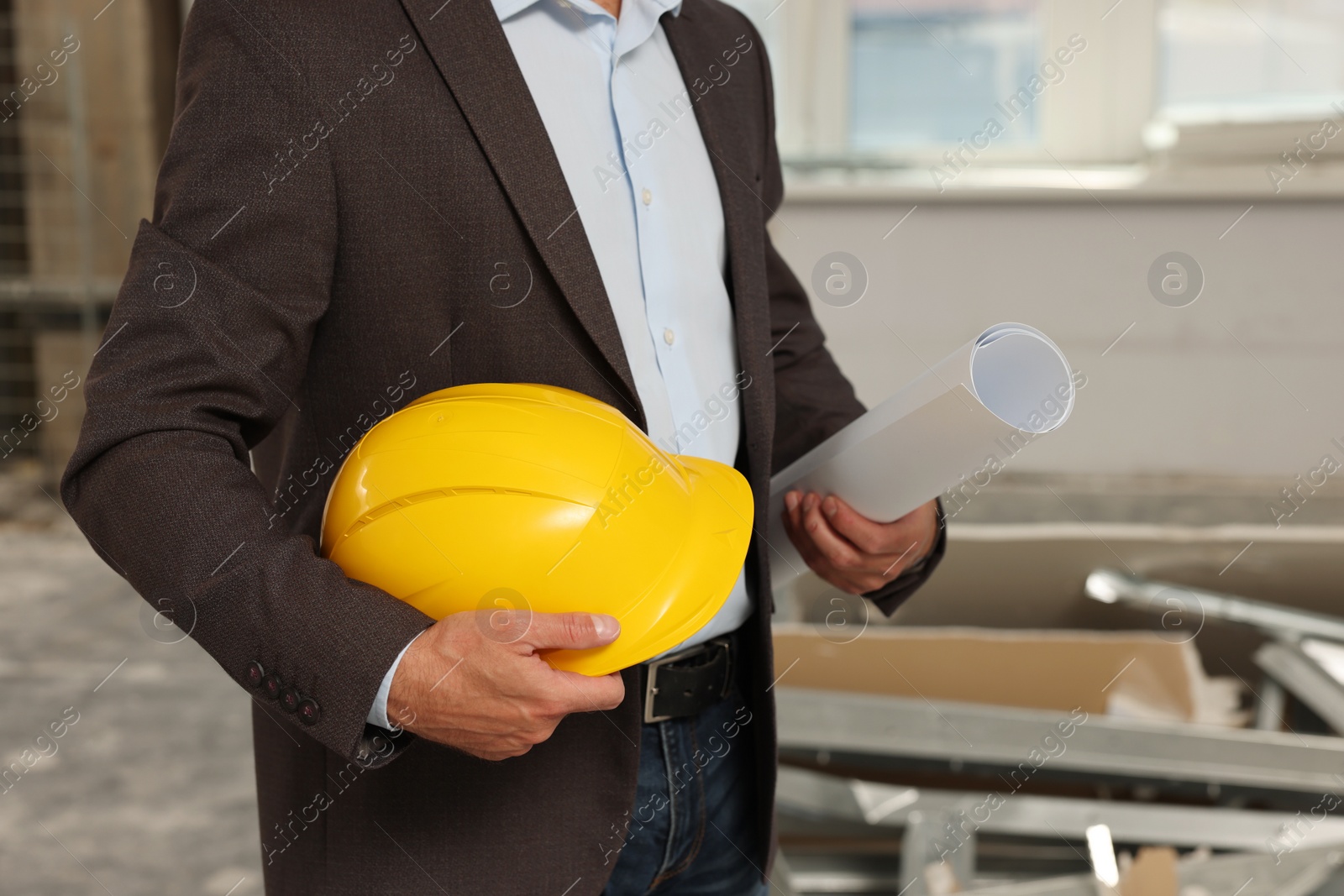 Photo of Professional engineer with hard hat and draft indoors, closeup