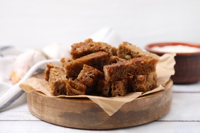 Delicious crispy rusks on white wooden table