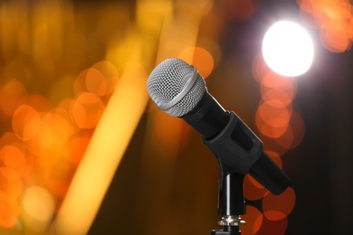 Microphone against festive lights, space for text. Musical equipment