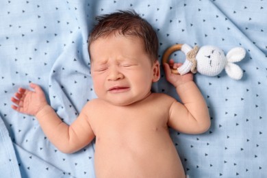 Photo of Cute newborn baby with toy bunny sleeping on bed, top view