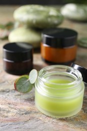 Jars of cream on textured table, closeup. Body care products