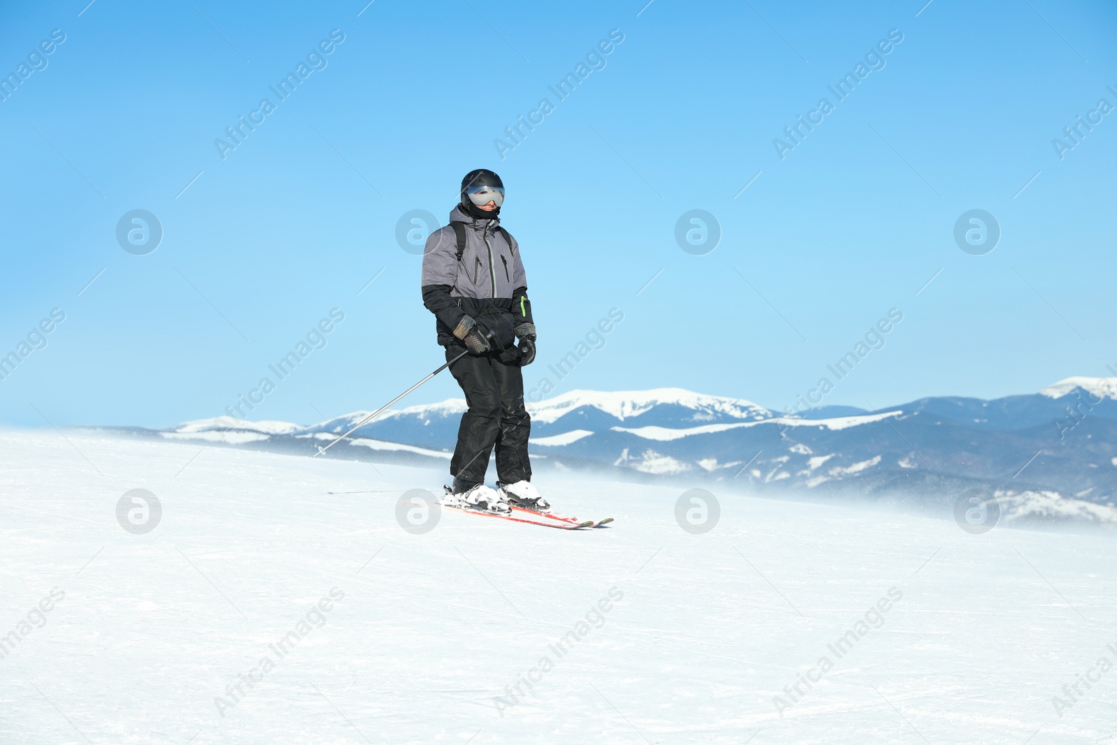 Photo of Male skier on snowy slope in mountains. Winter vacation