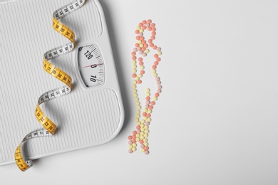 Photo of Composition with slim woman silhouette made of weight loss pills on white background, top view