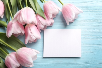 Photo of Beautiful tulips and card for Mother's Day on wooden background, top view