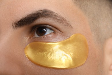 Photo of Man with golden under eye patch, closeup