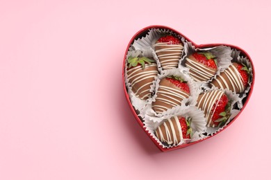 Photo of Heart shaped box with delicious chocolate covered strawberries on pink background, top view. Space for text