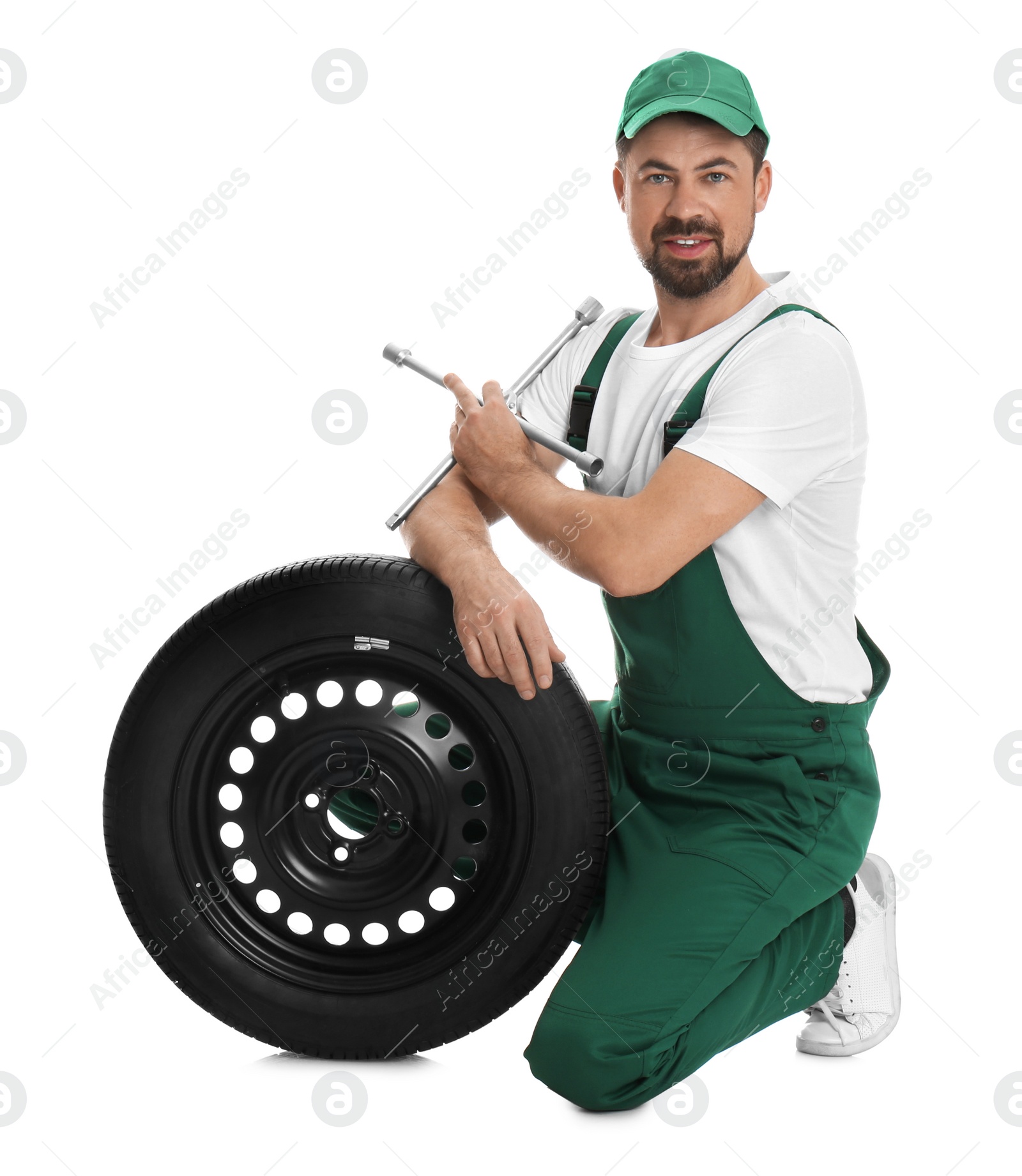 Photo of Professional auto mechanic with wheel and lug wrench on white background