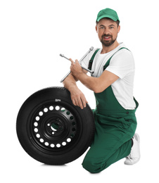 Professional auto mechanic with wheel and lug wrench on white background