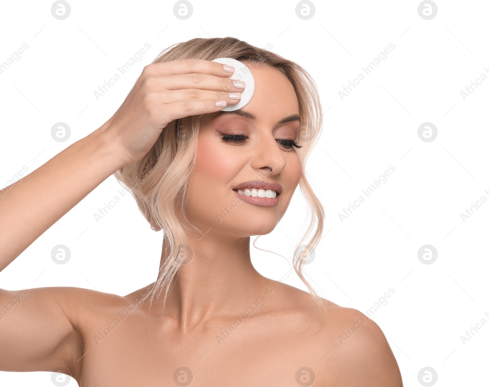 Photo of Smiling woman removing makeup with cotton pad on white background