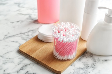 Composition with cotton swabs on marble table. Space for text