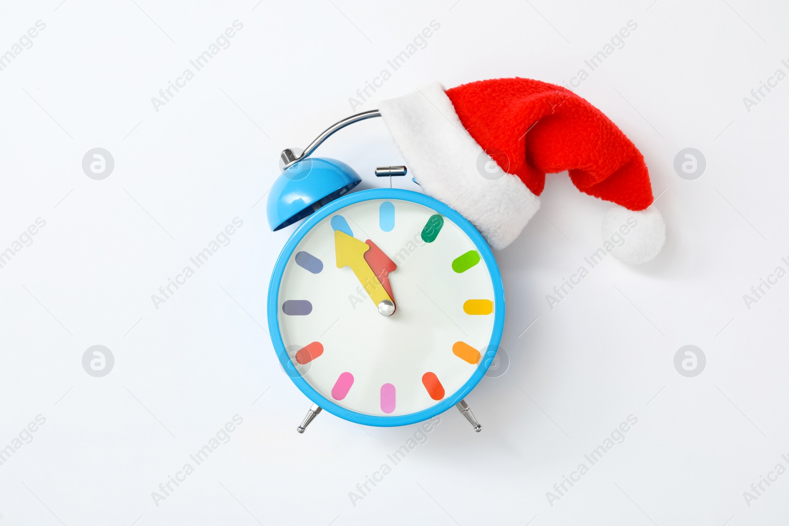 Photo of Alarm clock with Santa hat on white background, top view. New Year countdown