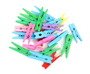 Pile of colorful wooden clothespins on white background, top view