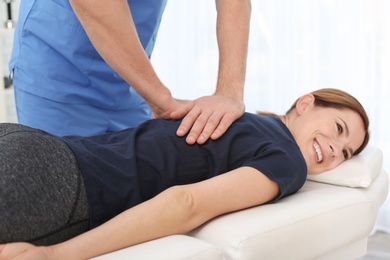 Photo of Physiotherapist working with patient in clinic. Rehabilitation therapy