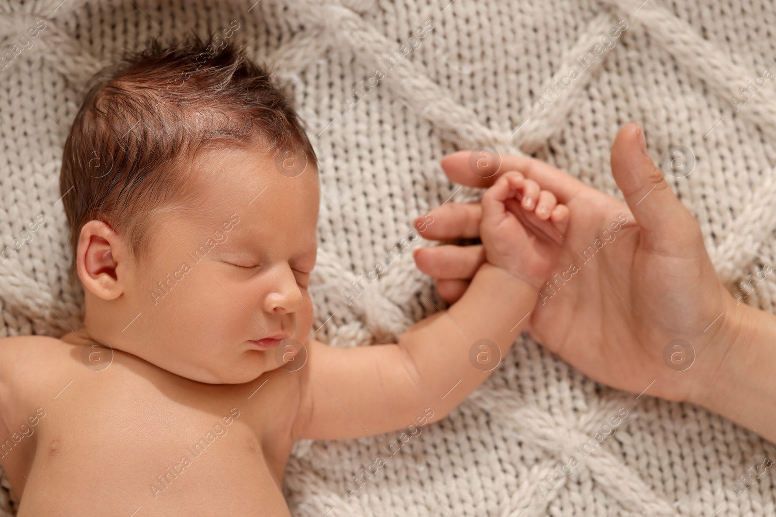 Photo of Mother with her newborn baby on beige blanket, top view. Lovely family