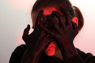 Woman with hands painted in black color on white background