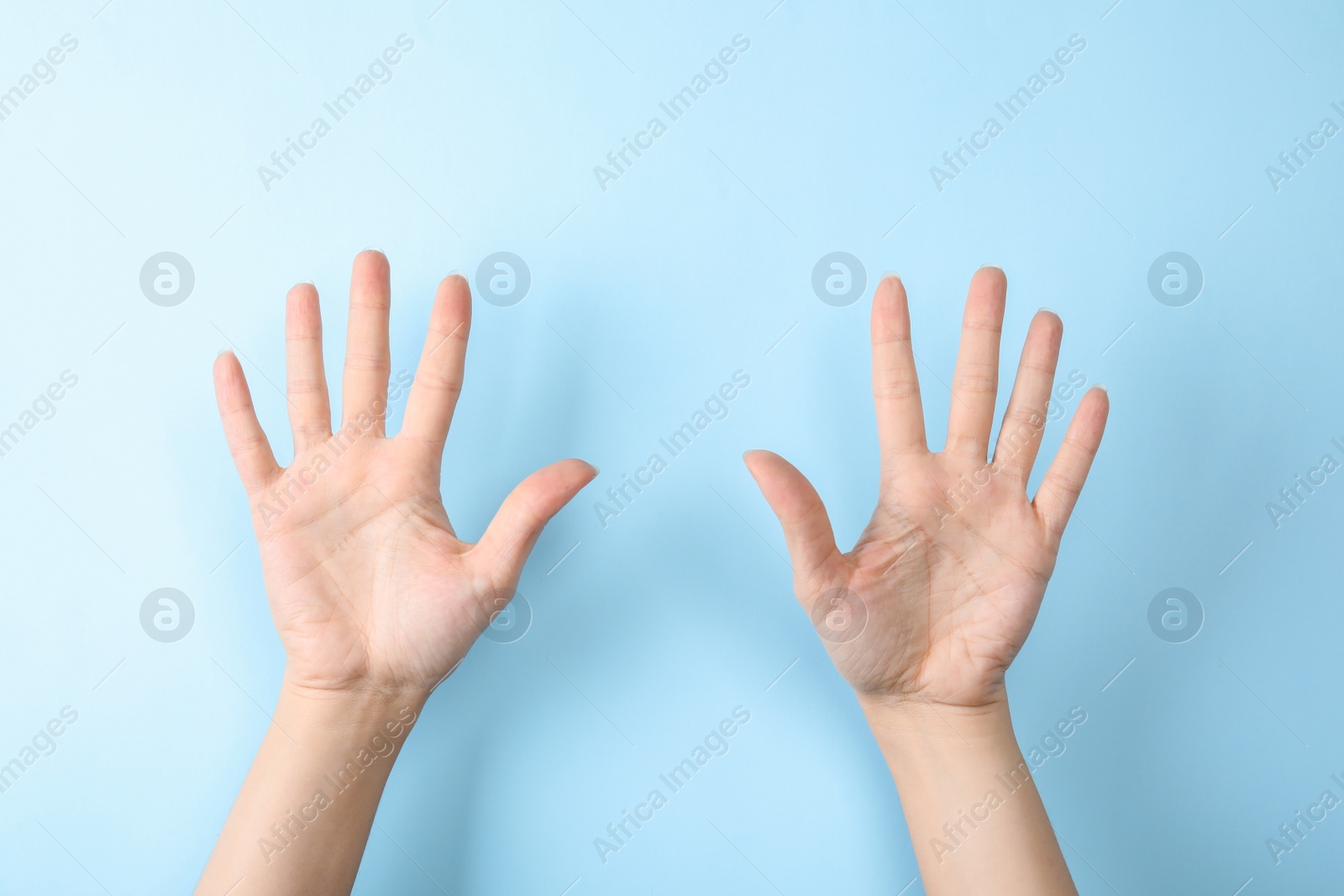 Photo of Woman showing sign ten on color background, closeup. Body language