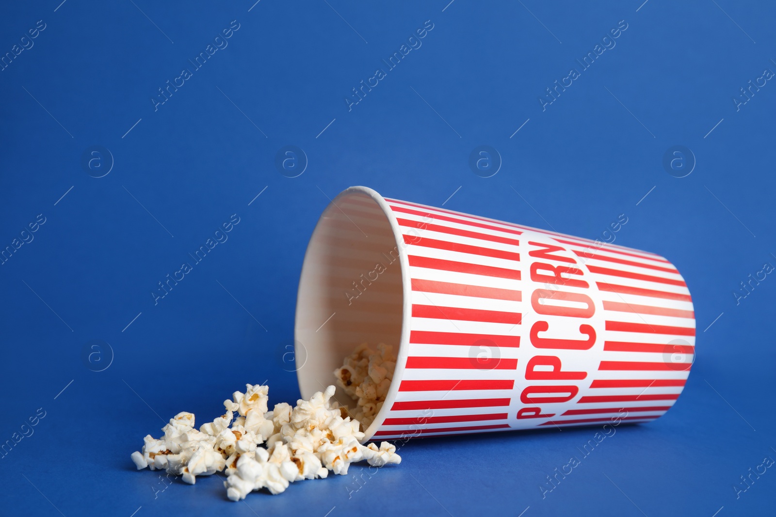 Photo of Tasty fresh pop corn on blue background