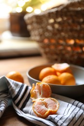 Photo of Fresh ripe tangerines and napkin on wooden table