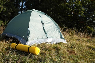 Sleeping mat near camping tent outdoors. Tourism equipment