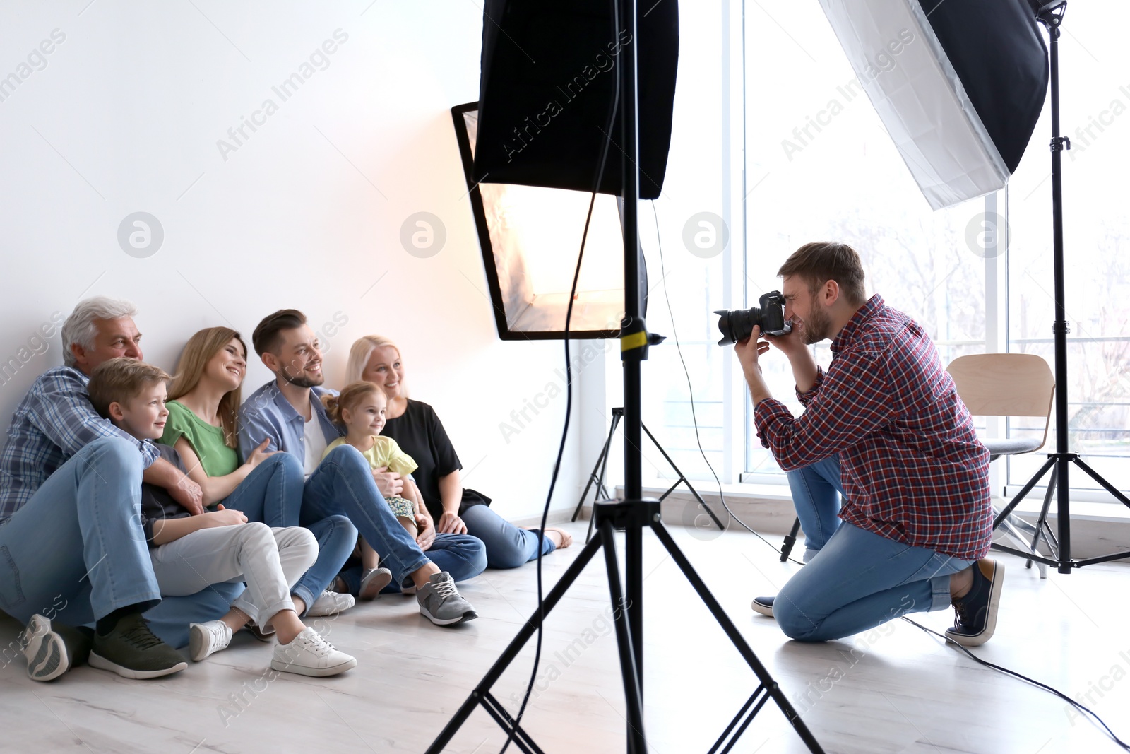 Photo of Professional photographer taking photo of family in studio