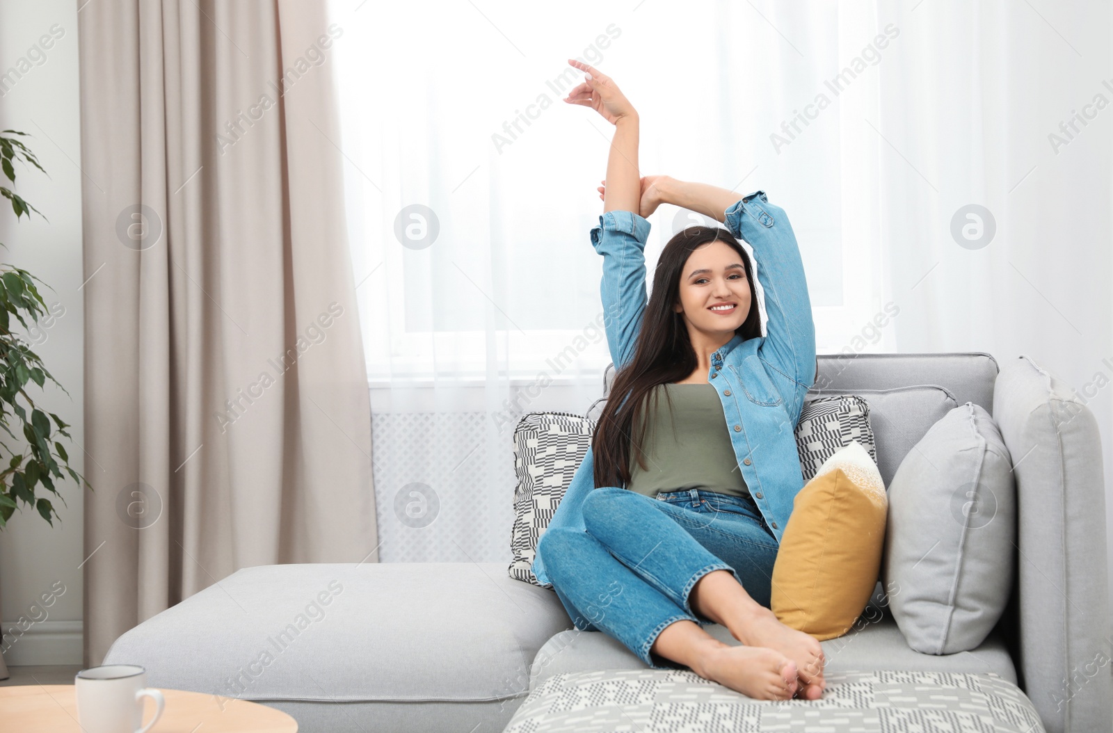 Photo of Young woman relaxing on couch at home