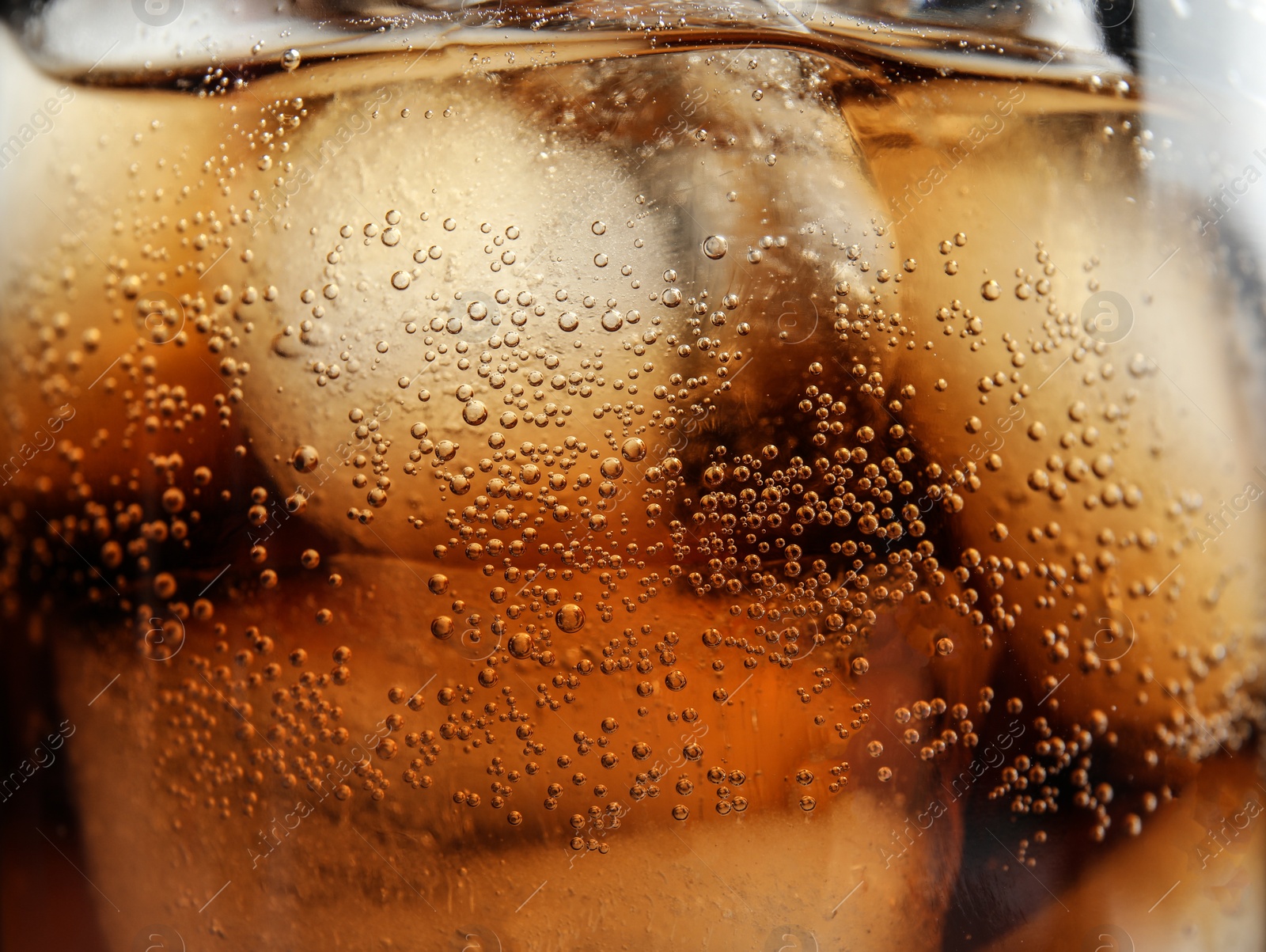 Photo of Glass of tasty refreshing cola with ice cubes, closeup