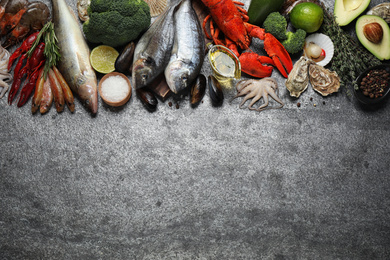 Photo of Fresh fish and different seafood on grey table, flat lay. Space for text