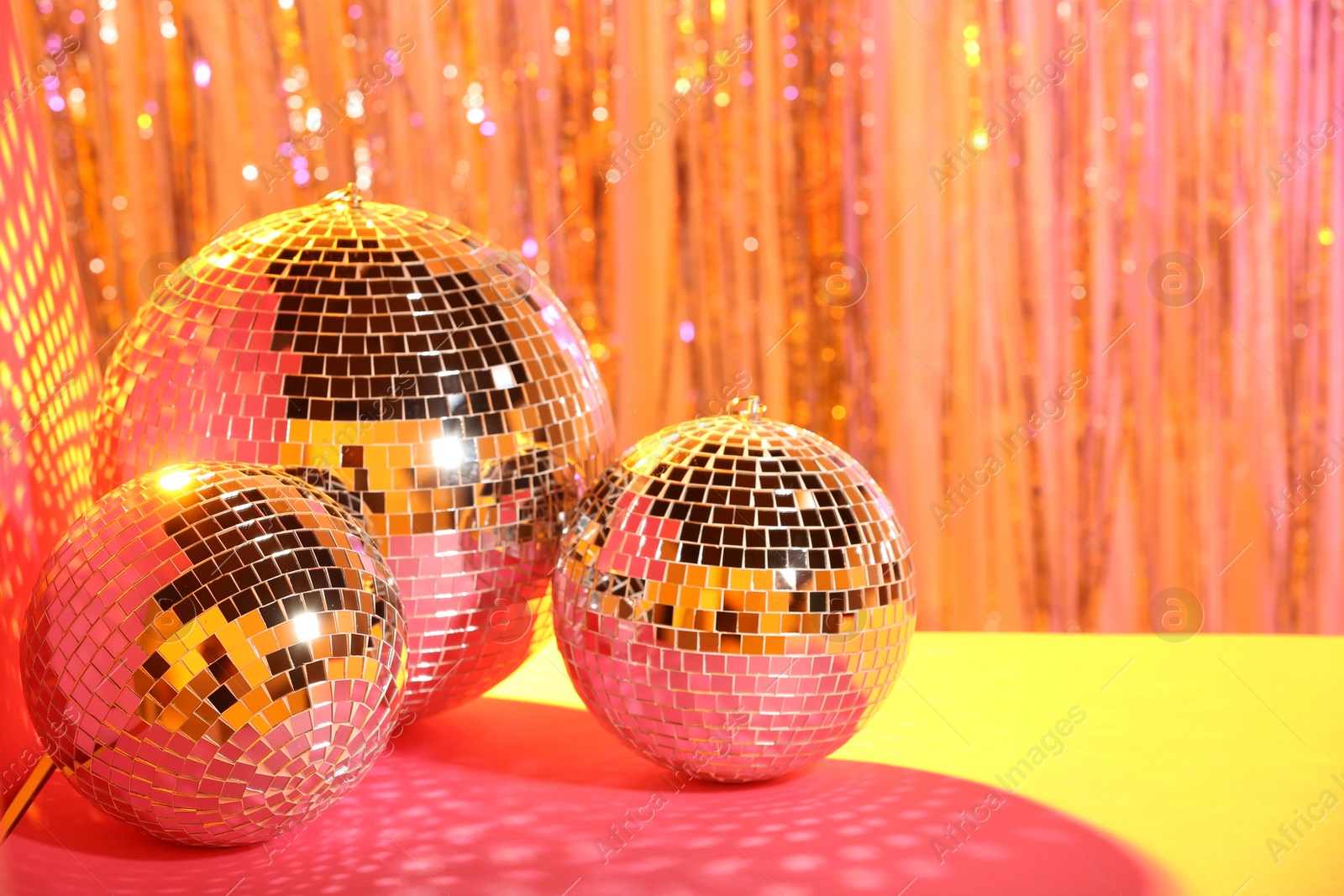 Photo of Shiny disco balls on blurred background, color toned. Space for text