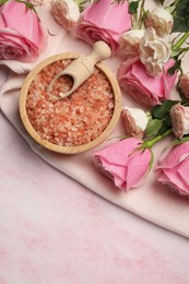 Photo of Aromatic sea salt and beautiful roses on pink marble table, top view. Space for text