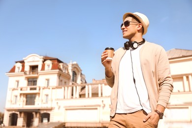 Photo of Happy man with coffee on city street in morning