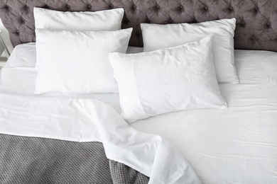 Soft white pillows on comfortable bed, closeup