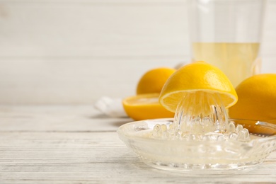 Freshly squeezed lemon juice on white wooden table. Space for text