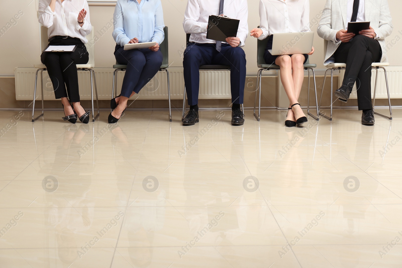 Photo of People waiting for job interview in office hall, closeup