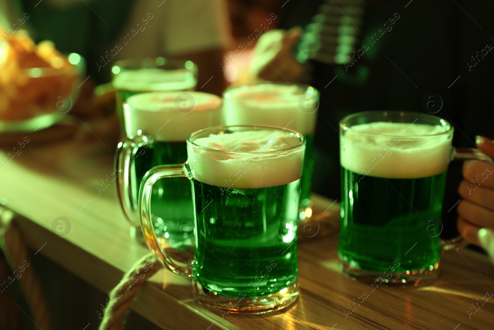 Photo of Fresh beer on wooden table in pub. St Patrick's day celebration