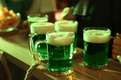 Photo of Fresh beer on wooden table in pub. St Patrick's day celebration