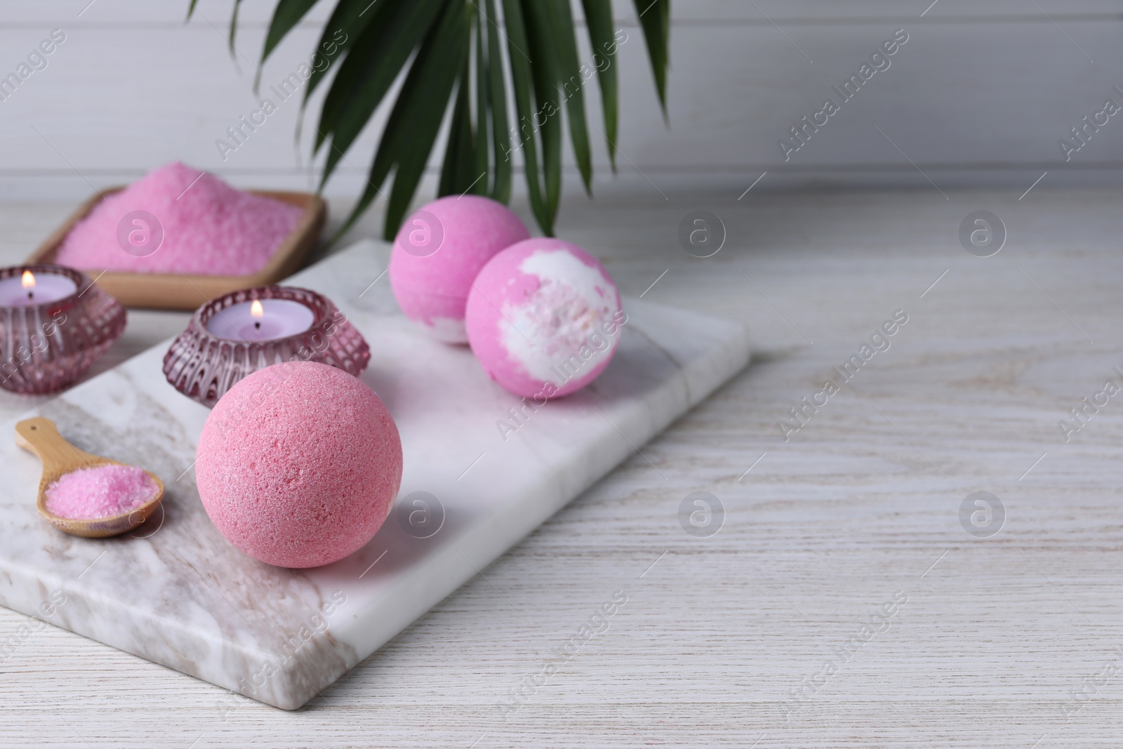 Photo of Beautiful composition with aromatic bath bombs on white wooden table, space for text