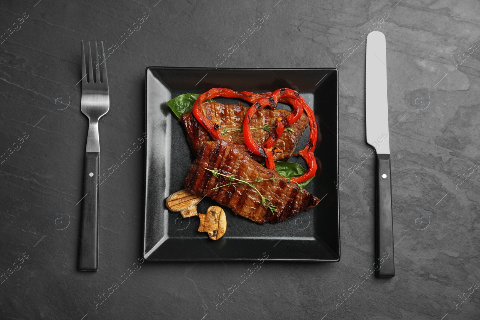 Photo of Flat lay composition with grilled meat on black table
