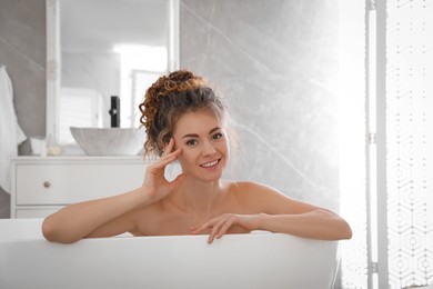 Photo of Beautiful woman relaxing in bathtub at home