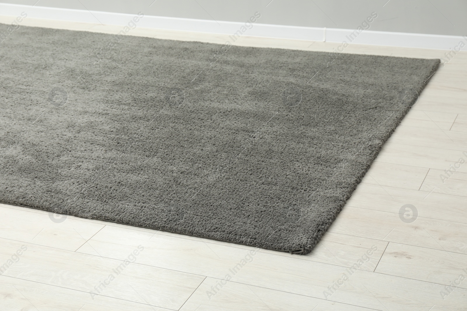 Photo of Soft grey carpet on white laminated floor indoors