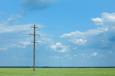 Photo of Field with telephone pole under cloudy sky